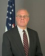 A person wearing a suit and tieDescription automatically generated with medium confidence